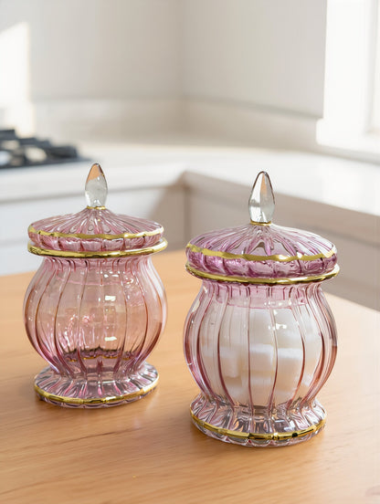 Pair of rose pink Egyptian glass candy jars with gold rims and teardrop finials