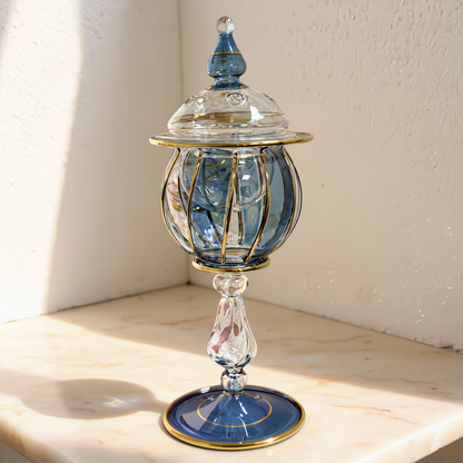 Blue and gold lidded Egyptian glass jar in soft studio daylight