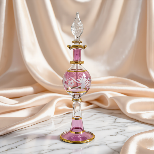 Hand-blown Egyptian glass perfume bottle in rose pink with gold trim on ivory satin drape