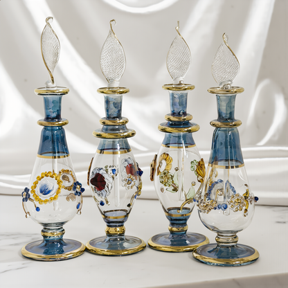 Tall hand-blown Egyptian glass perfume bottle in blue and gold on ivory satin