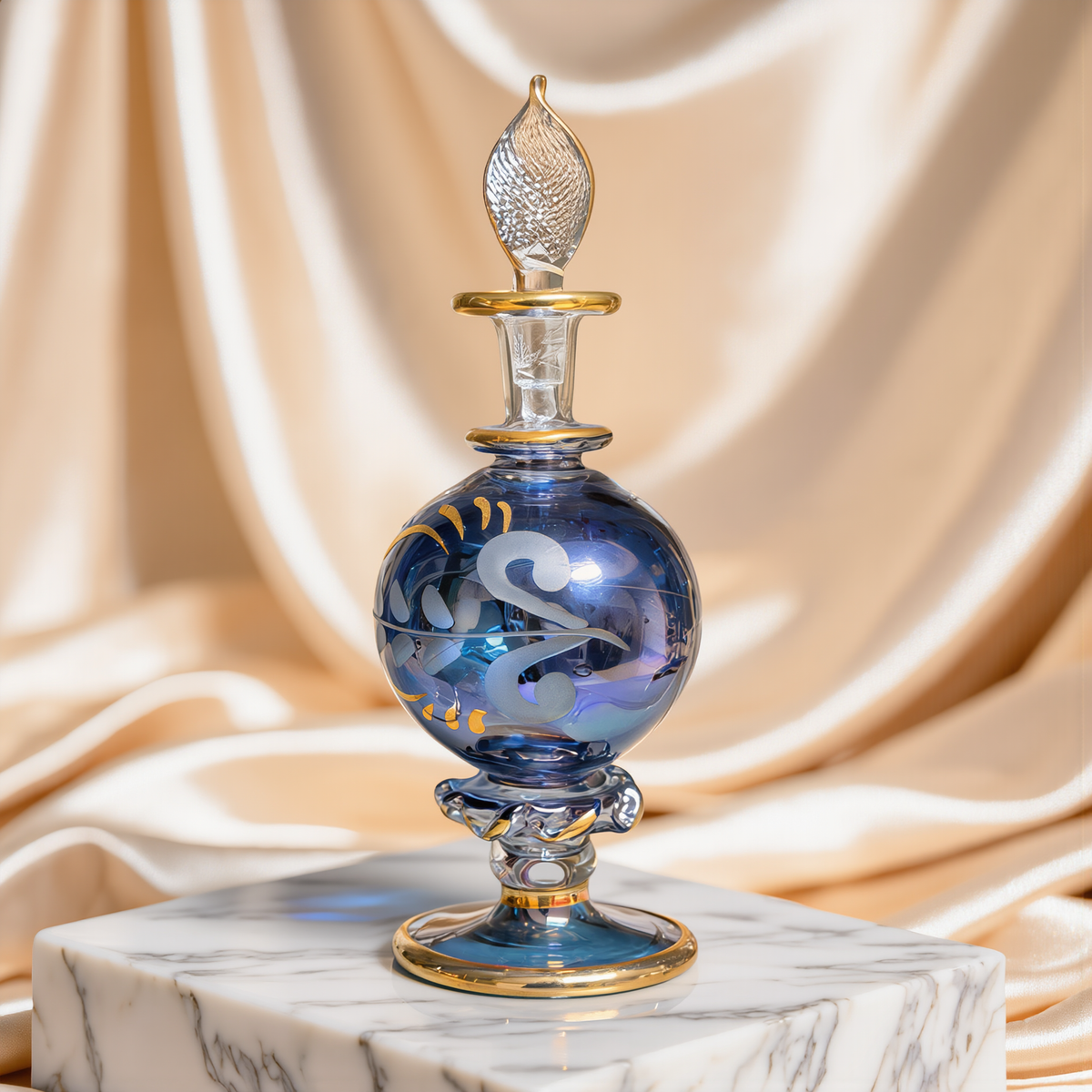 Round blue Egyptian glass perfume bottle with gold work on ivory satin drape