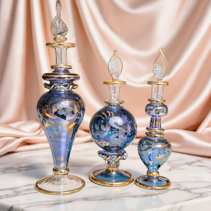 Round blue Egyptian glass bottle with gold decoration on ivory satin
