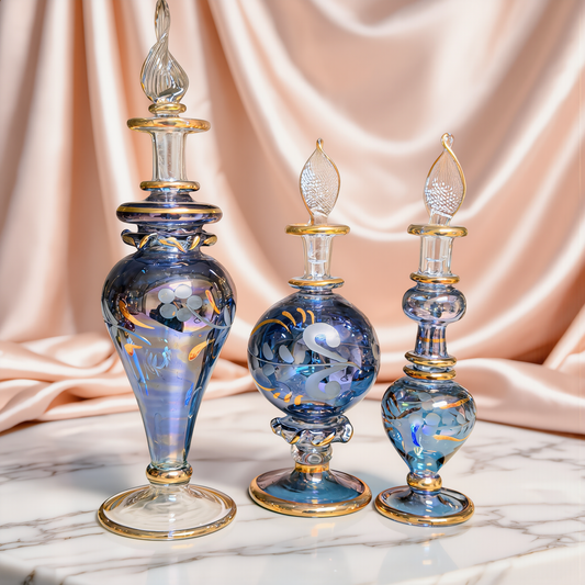 Round blue Egyptian glass bottle with gold decoration on ivory satin
