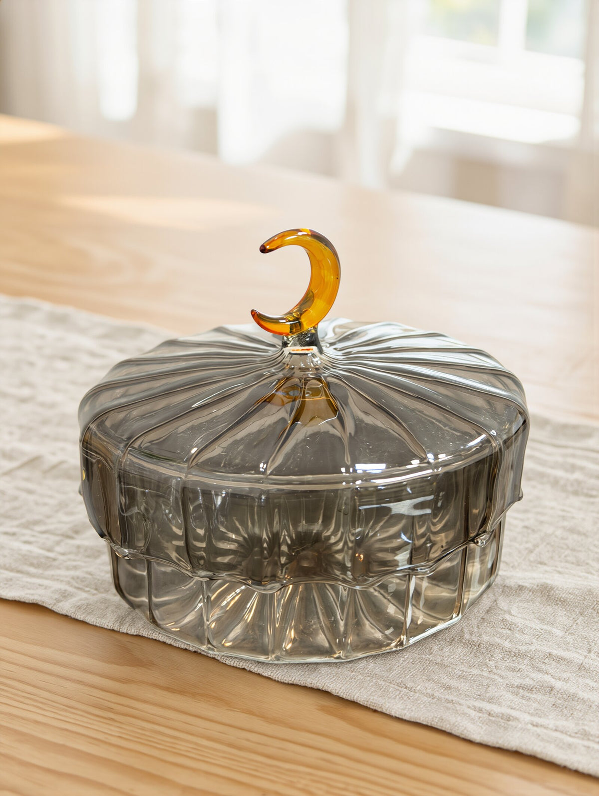 Hand-blown Egyptian glass crescent moon sweet box on a linen table runner