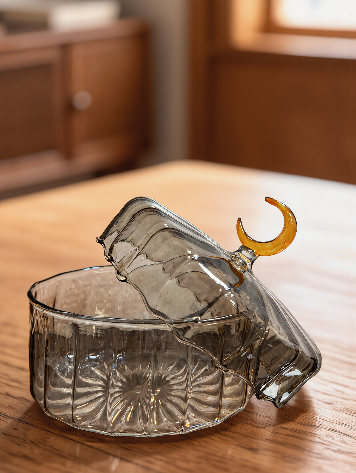 Open crescent moon candy box in smoke Egyptian glass on a wooden table